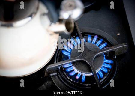 A closeup of a kettle on a lit gas stove Stock Photo