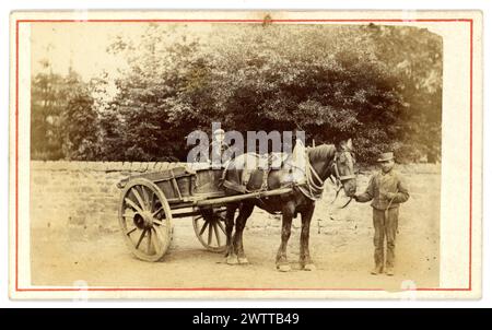 Original Victorian carte de visite (visiting card or CDV) of country image of long ago, a rustic farmhand standing next to a horse and cart, with a young boy, possibly his son, taking a ride in the cart. Circa 1860's. U.K. Stock Photo