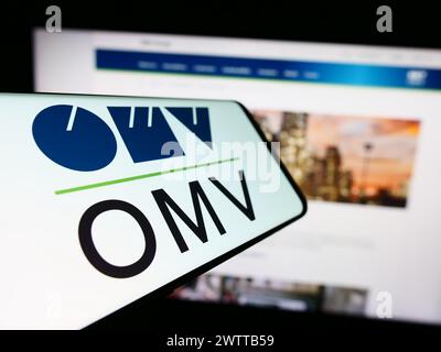 Smartphone with logo of Austrian oil and gas company OMV Aktiengesellschaft in front of business website. Focus on center-left of phone display. Stock Photo