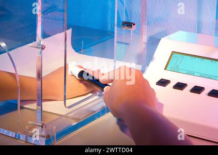 Hands conducting a scientific experiment with a futuristic device Stock Photo