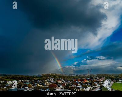 Dramatic sky over a suburban landscape with a rainbow Stock Photo