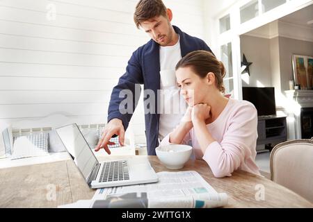 Two people working on a laptop at a home office Stock Photo