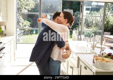 Couple hugging in a bright kitchen. Stock Photo
