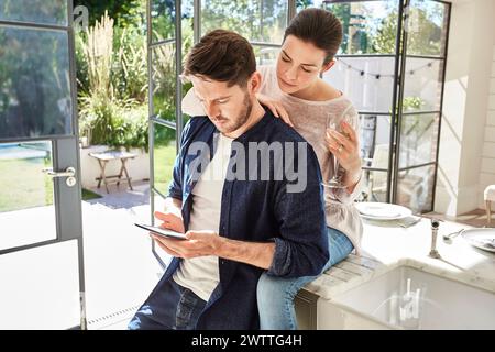 Couple using tablet in a bright kitchen Stock Photo
