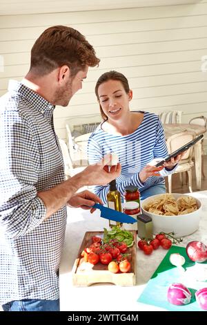 Couple preparing food together in a kitchen Stock Photo
