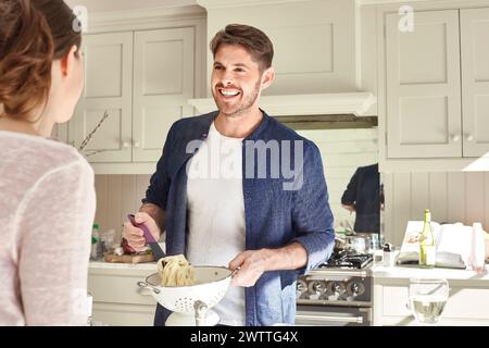 Man smiling while cooking in a kitchen Stock Photo