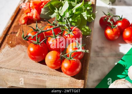 Fresh tomatoes on a wooden cutting board with basil. Stock Photo
