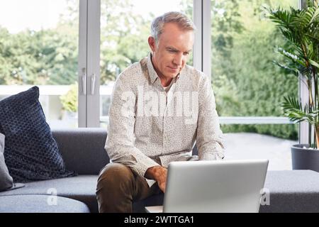 Man working on laptop at home Stock Photo
