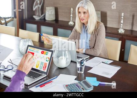 Woman working at a desk with a laptop and documents Stock Photo