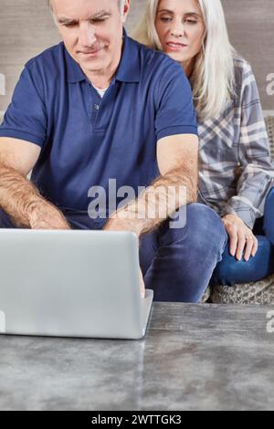 Couple using a laptop on a couch Stock Photo