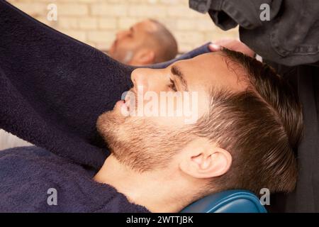 Man receiving a haircut in a barber shop Stock Photo