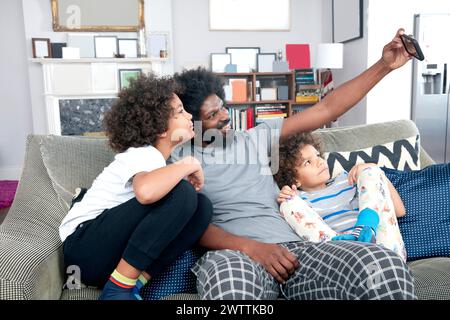 Family taking a selfie on a couch. Stock Photo