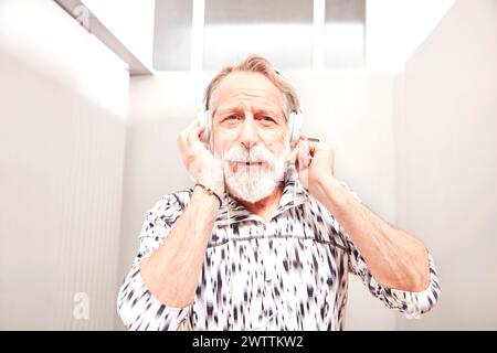 Elderly man enjoying music with headphones Stock Photo