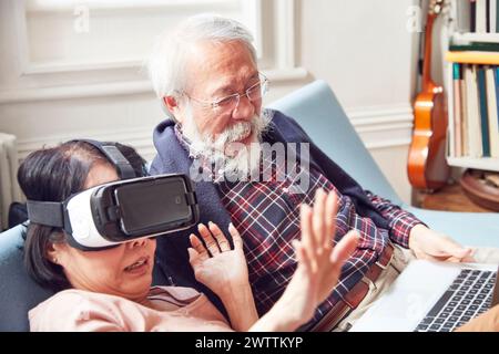 Elderly couple with woman using VR headset Stock Photo