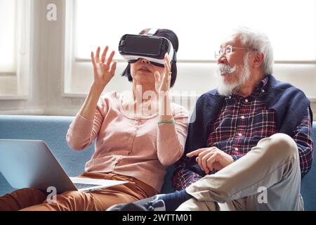 Elderly couple experiencing virtual reality on the couch Stock Photo