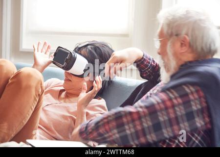 Woman using VR headset with man beside her Stock Photo