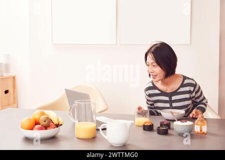 Woman enjoying a healthy breakfast at a table. Stock Photo