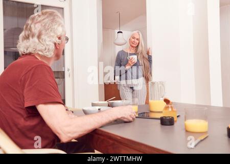 Senior couple enjoying breakfast in a cozy kitchen Stock Photo