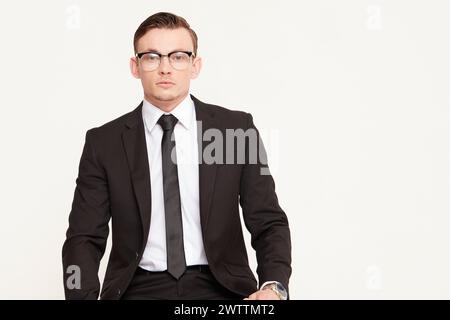 Man in black suit and glasses posing professionally Stock Photo