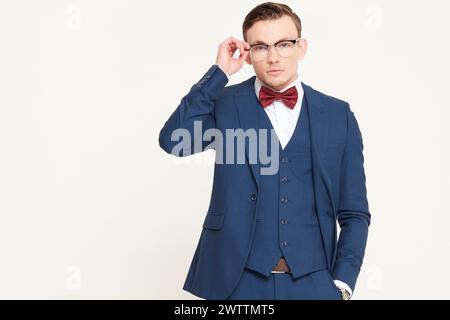 Man in a blue suit adjusting his glasses Stock Photo