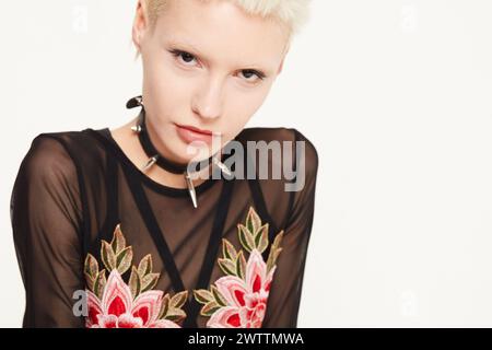 Woman in black floral dress against white backdrop Stock Photo