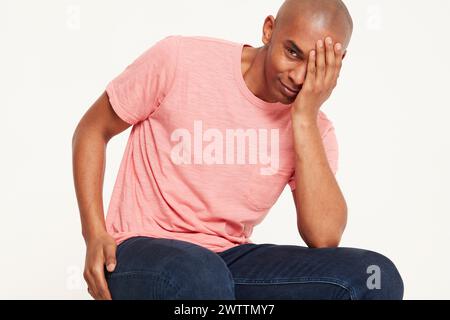 Man in pink shirt facepalming Stock Photo
