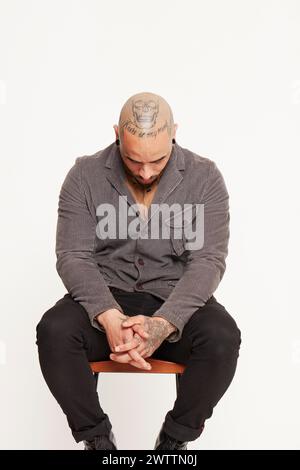 Man with tattoos sitting on a chair Stock Photo