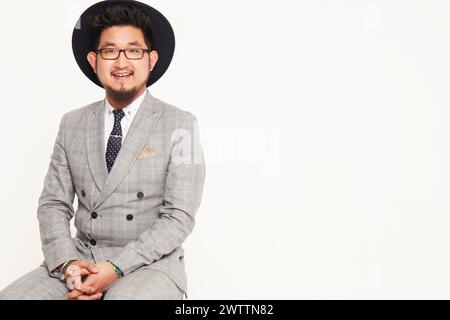 Man in a hat sitting in a suit Stock Photo