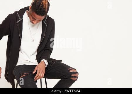 Fashionable man sitting and looking down Stock Photo