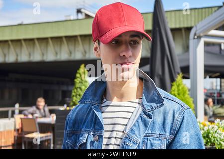 Young man with red cap smiling outdoors Stock Photo