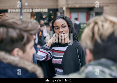 Woman smiling among friends outdoors Stock Photo