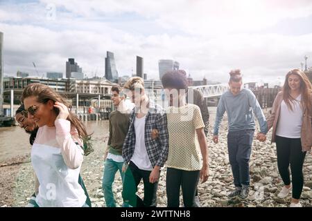 Group of friends walking by the riverbank Stock Photo