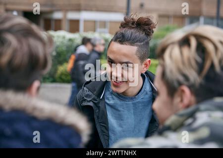 Group of young adults engaged in conversation outdoors. Stock Photo