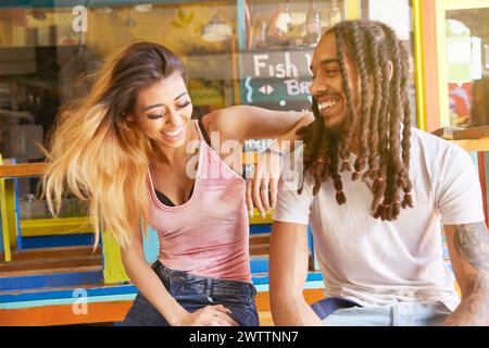 Smiling couple sitting together at a colorful café booth Stock Photo