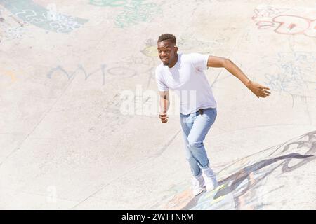Man skateboarding at a graffiti-covered skatepark. Stock Photo