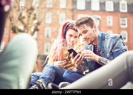 Two friends sharing music on a phone Stock Photo