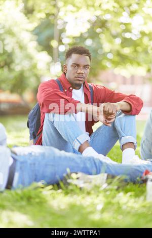 Young man sitting outdoors in a park Stock Photo