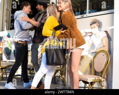 Friends hugging outside a cafe Stock Photo