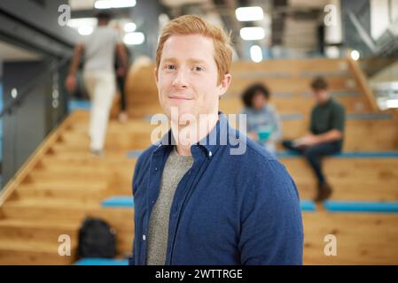 Smiling man standing in front of staircase indoors Stock Photo