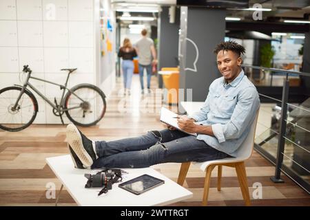 Man with notebook sitting in a modern office Stock Photo