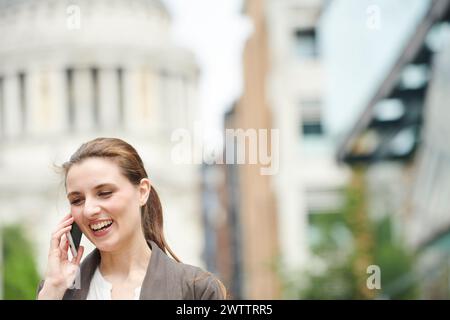 Smiling woman talking on the phone in urban setting Stock Photo
