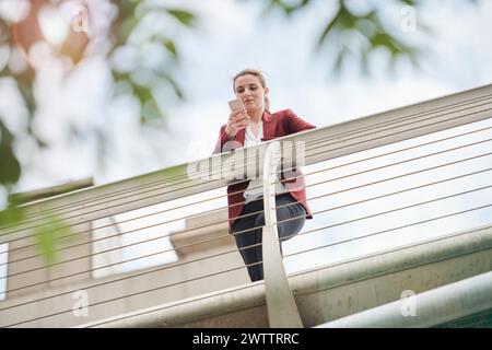 Woman leaning on bridge railing from a low angle view Stock Photo