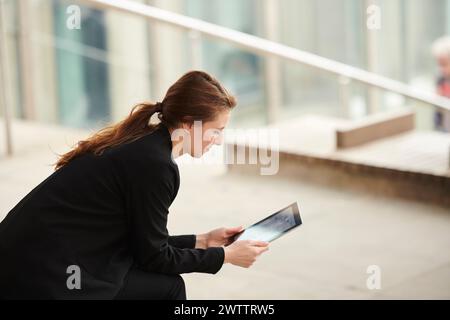 Businesswoman using tablet outdoors Stock Photo