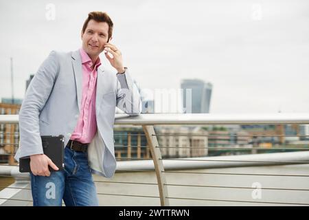 Man talking on phone with cityscape in background Stock Photo