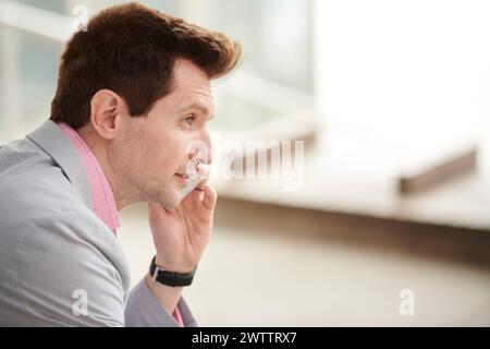 Man on a phone call looking thoughtful Stock Photo