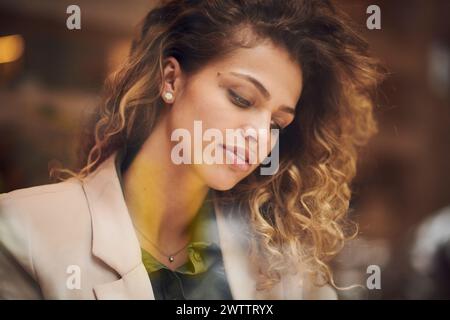 Woman with curly hair looking down thoughtfully Stock Photo
