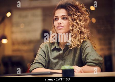 Woman with curly hair sitting in a cafe Stock Photo