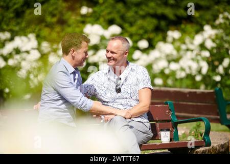 Two men chatting on a park bench Stock Photo - Alamy