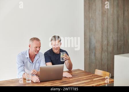 Two men working together on a laptop Stock Photo