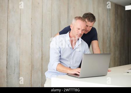 Two men working together on a laptop Stock Photo